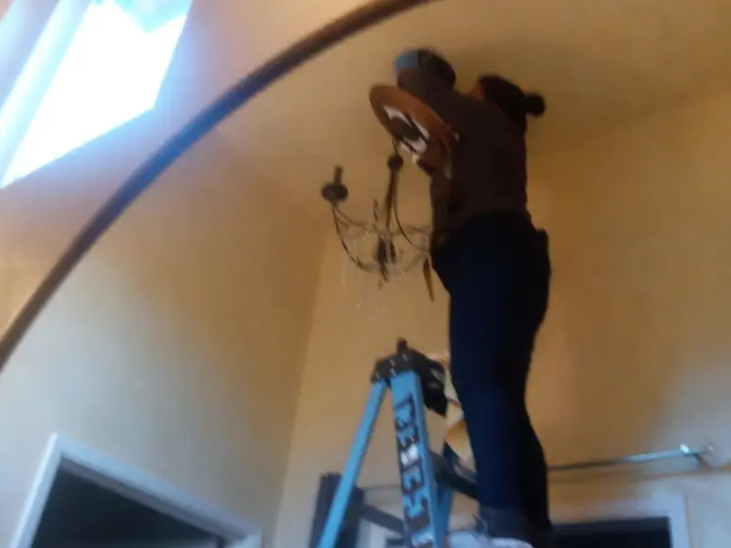 Electrician installing a chandelier in a Red Wing residence